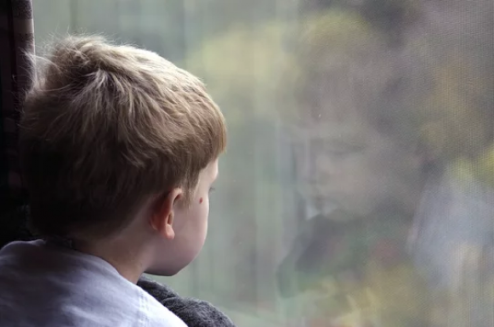 sad kid looking out window